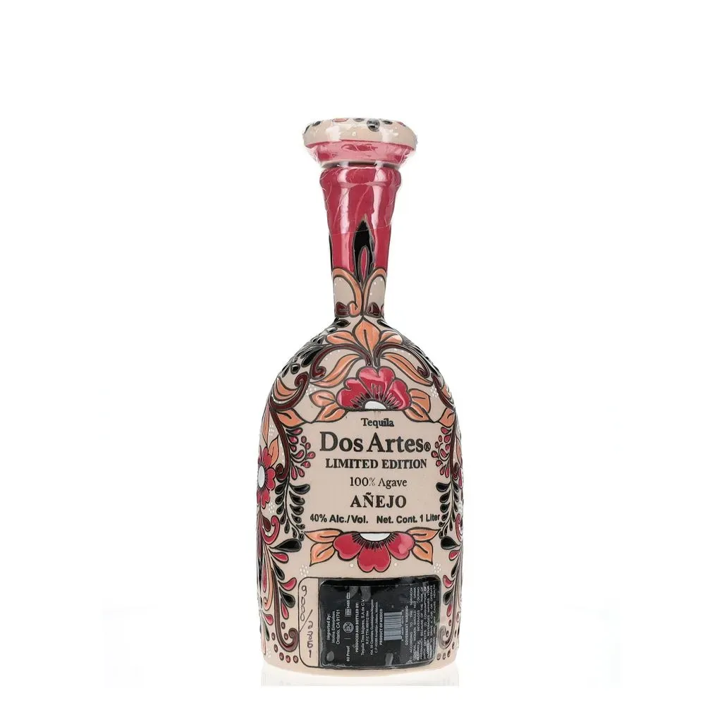 The Dos Artes Anejo "Day of the Dead" edition is a beautifully crafted tequila that comes in a decorative ceramic bottle, adorned with vibrant and intricate designs inspired by the Mexican holiday Día de los Muertos. The bottle features a skull-like face with detailed floral and geometric patterns in shades of red, orange, and black against a light background, capturing the festive and celebratory spirit of the holiday. This special edition is likely a type of Anejo tequila, given the cultural references and the name "Dos Artes," which suggests a blend of artistry in both the tequila's creation and its presentation. The bottle is not only a tribute to the rich traditions of Mexico but also a collectible piece of art that tequila enthusiasts and collectors would be proud to display
.