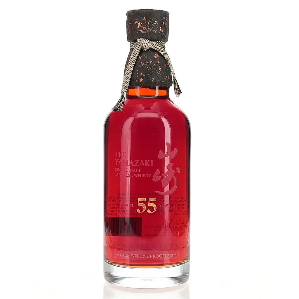 The oldest whisky produced to date by Suntory, the Yamazaki 55 year old represents the absolute pinnacle of rare whisky.
Crafted from two unique styles of Yamazaki, one distilled in 1960 and matured in Mizunara casks as well as a 1964 vintage matured in white oak casks, it was delicately blended and bottled in 2020.
The bottle itself is a work of art, encased in a crystal bottle adorned with gold dust and lacquer, wrapped in handmade washi paper, and presented in a bespoke Mizunara wood box.
Yamazaki was the first whisky distillery in Japan, founded in 1924 by Shinjiro Torri’s firm Kotobukiya under the helm of Masataka Taketsuru, who had just returned from Scotland after a three year trip learning how to make whisky. Torri signed Taketsuru to a 10 year contract and tasked him with production of a Japanese made whisky. It would take till 1929 before Suntory white label would be released, ultimately failing due to its peated style. The pair would split at the end of Taketsuru’s contract, but Yamazaki would ultimately prosper once the unpeated Kakubin was released.
For much of the 20th century Japanese whisky was relegated to cheap blended products, with Yamazaki making grain and malt whisky for its blends as well as likely using cheap imported Scotch whisky. But in 1984 the firm pivoted, and began releasing Yamazaki as a pure malt whisky. This was risky as the wider whisky market was still almost entirely drinking blended whiskies, but Suntory wanted to differentiate. They launched Hibiki in 1989 to satisfy the blended market and even launched an 18 year old and 25 year old Yamazaki malt whisky as the 1990s ticked along.
As the turn of the millennium crept around Japanese whisky was winning more and more awards. And by the 2010s demand for the spirit had pivoted and age stated expressions of Japanese whisky were rapidly being discontinued. Yamazaki especially suffered and the 18 has become a super premium offering in the last decade. Old stocks of this esteemed distillery are few and far between, and those that do survive are now amongst the most sought after bottles in the world.
The use of Mizunara oak came out of necessity as imported American white oak became difficult to acquire post WWII. The Japanese whisky makers turned to local oak to try and satisfy their need for casks. Mizunara is notoriously difficult to work with, often being used instead for furniture. These endemic Japanese trees need 200 years on average to meet requirement for cask making and so are both expensive and highly allocated. Despite this difficulty the Japanese makers at Suntory found the oak to impart a wholly unique flavour, often drawing parallels to notes of coconut and sandalwood. Suntory continued the use of these precious oak casks and they have been a core component of what makes Yamazaki single malt so special.